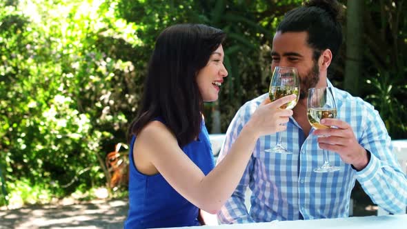 Smiling romantic couple toasting wine glasses alt