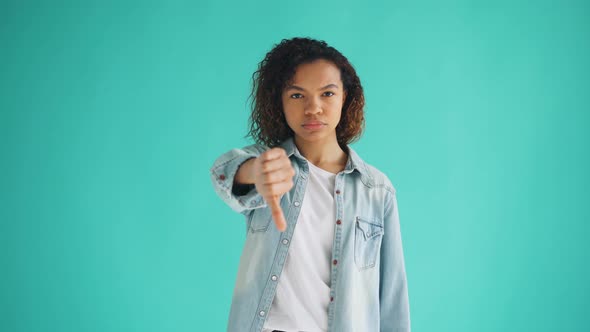 Portrait of African American Lady Stretching Arm Forward Showing Thumbs-down alt