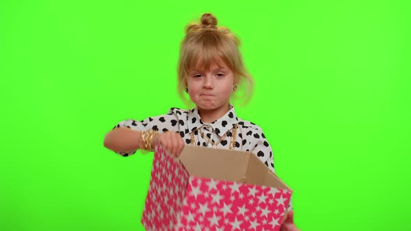 Child Girl Unwrapping Birthday Gift and Expressing Disappointment Dislike Bad Present Dissatisfied alt