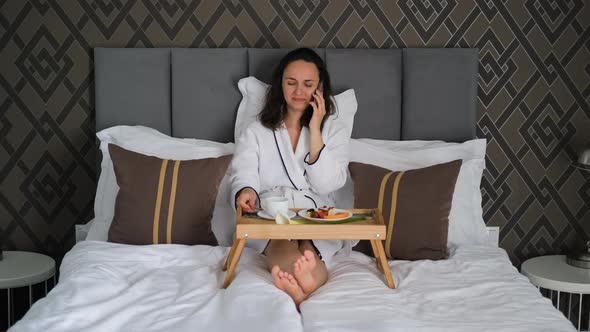 Female Talking By Phone While Having Breakfast alt