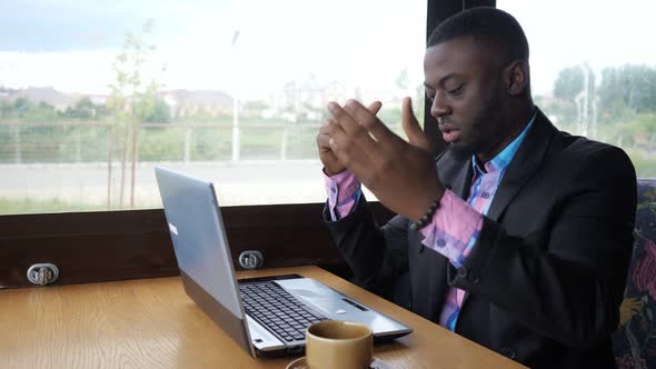 Black Man Works on Laptop but It's Broken and He Nervous and Knocking on Keys. alt