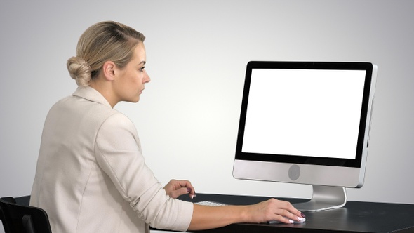 Young woman working in office sitting at desk, looking alt