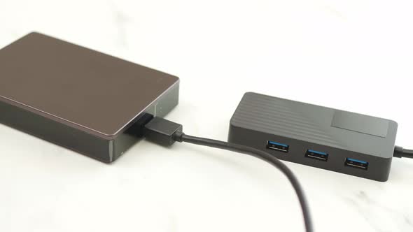 Man connect cable USB of the external hard disk to the hub for backup and transfer digital data. alt