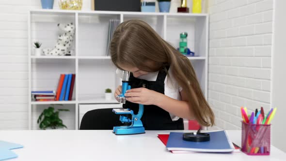 Concentrated Teen Girl Looking Through Modern Scope on Chemistry Lesson Knowledge alt