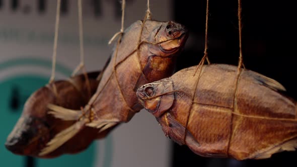 Salted Dried Cured or Smoked Sea Bream Fish Hanging in a Rope in the Street Food Market Place alt
