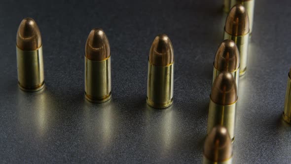 Cinematic rotating shot of bullets on a metallic surface - BULLETS  alt