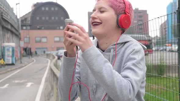 Young woman listening music using smartphone alt