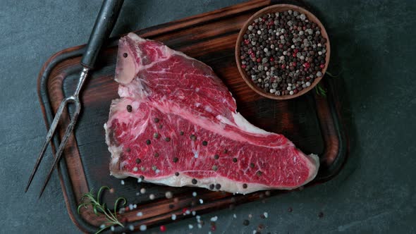 Super Slow Motion Shot of Falling Pepper and Salt on Fresh Tbone Meat at 1000 Fps alt