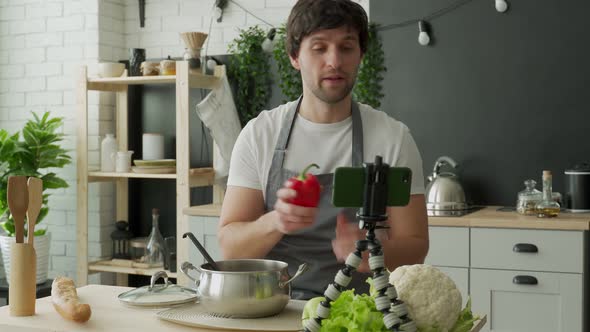 Young Chef in an Apron Filming Himself for a Cooking Blog While Cooking a Healthy Meal with alt