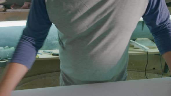 Portrait of male surfboard maker in his workshop alt