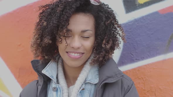 Beautiful Smiling Young Womant with Afro Haircut Posing Outdoor with Graffiti alt