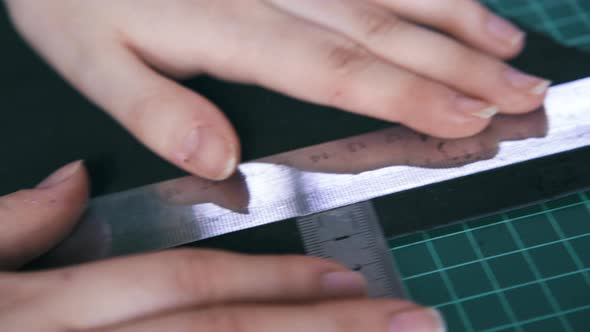 Tailor Measures Leather Cloth with Metal Rulers on Board alt