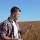 A Farmer in the Middle of a Soybean Field Examines the Stems of a Mature Plant - VideoHive Item for Sale