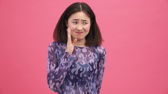 Pretty Asian woman suffering from bad smell alt