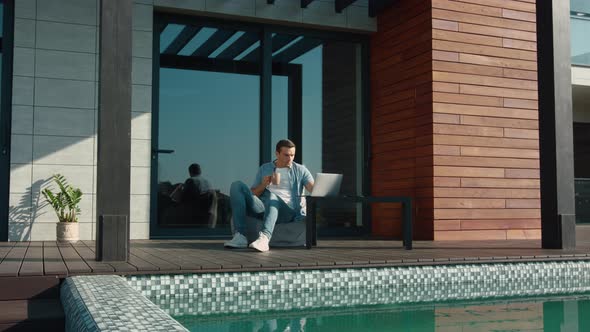 Happy Man Using Laptop at Luxury House. Business Man Using Technology at Home alt