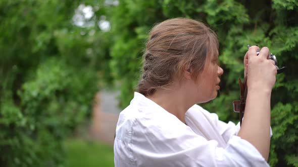 Side View Curios Talented Plussize Woman Taking Photos of Summer Nature in Green Garden Outdoors alt