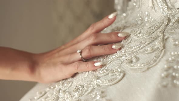 Girl Holds Hand On White Dress With Beautiful Pattern alt