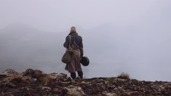 Man In Greatcoat Standing In Misty And Rocky Landscape alt