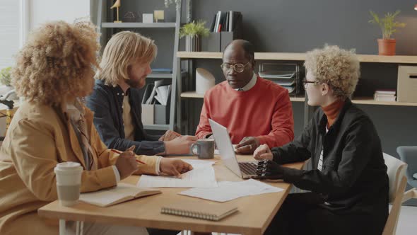 Woman with Prosthetic Arm Using Laptop at Business Meeting alt