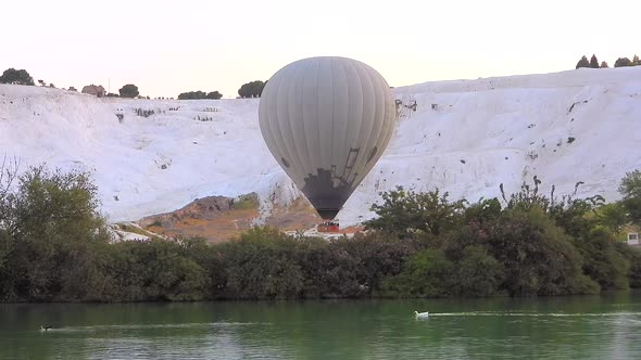 Hot Air Balloons in White Travertines and Lake of Pamukkale, a Touristic Natural World Heritage Site alt