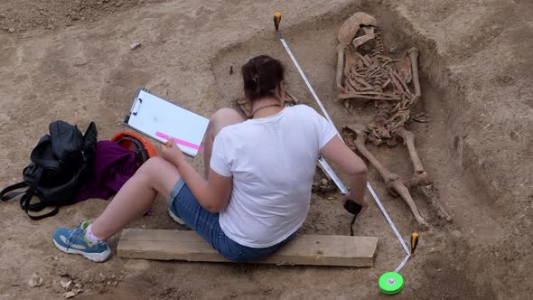 Young Archeologist Works on an Archaeological Site at Morning Sun Rays at Summer Heat alt