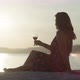 Romantic Landscape of the Sea a Girl Drinks Wine on the Beach at Sunset - VideoHive Item for Sale