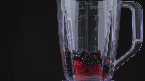 Milk is Poured Into a Blender Bowl with Berries alt