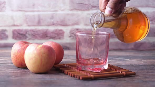 Apple Vinegar in Glass Bottle with Fresh Green Apple on Table alt