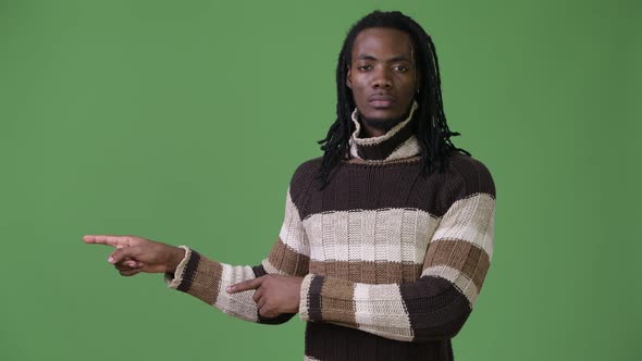 Young Handsome African Man with Dreadlocks Against Green Background alt