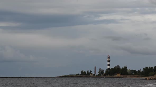 Clouds fly across the sky over the lighthouse. Lighthouse by the sea. time interval.