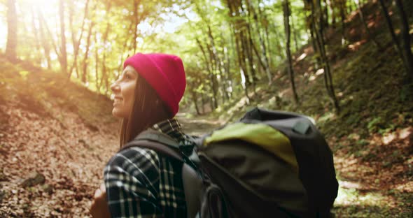 Backview of Woman with Backpack in Forest