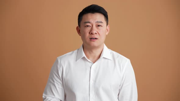 Pensive Asian businessman giving negative answer alt