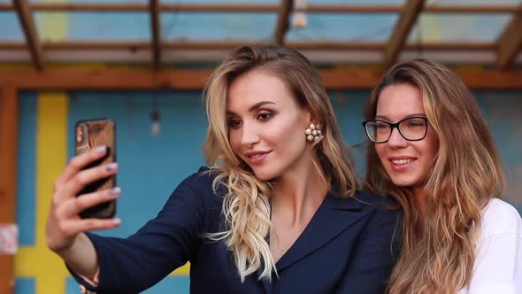 Two Attractive Women Taking Selfie on Phone and Posing