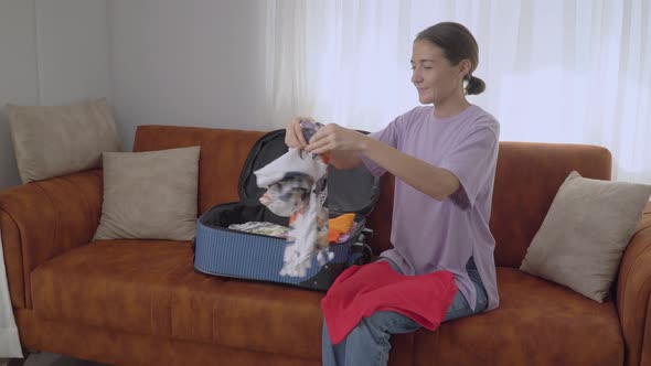 A Girl Packs a Suitcase for a Vacation in a Hot Country Folds Clothes