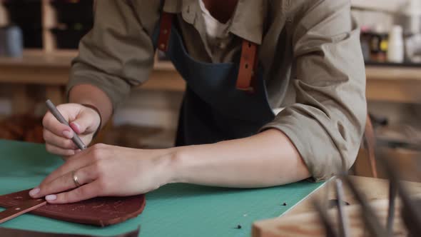 Currier Making Holes in Handmade Leather Strap alt