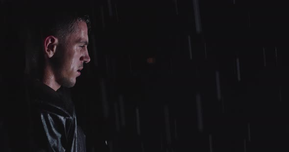 Portrait of the Determined Professional American Football Player in Dark Night Holding the Ball