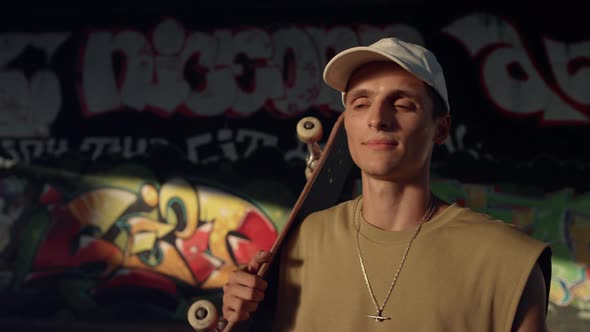 Casual Teenage Skater Walking Away with Skate Board on Shoulders at Skatepark alt