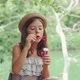 Summertime holidays. Portrait of cute caucasian girl sitting blowing a soap bubbles - VideoHive Item for Sale