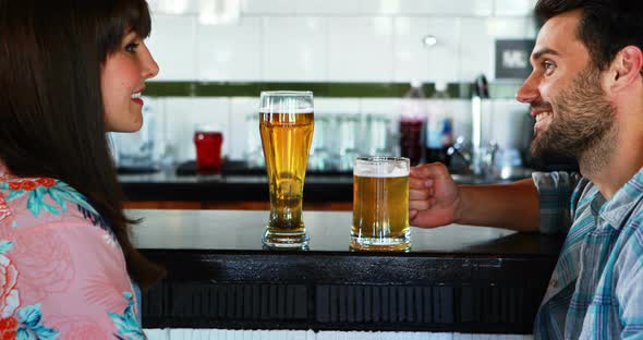 Happy couple interacting while having beer alt