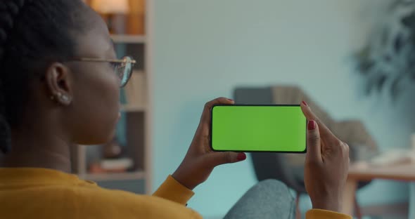 African American Woman Holding Smartphone with Green Screen alt
