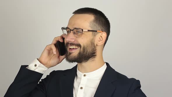 A Young Successful Businessman Is Talking with Partners on a Mobile Phone