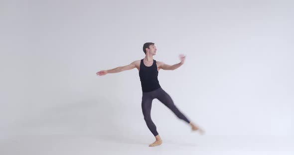 Elegant Male Ballet Dancer Performs Acrobatic Elements and Pirouette Ballet Dance on a White alt