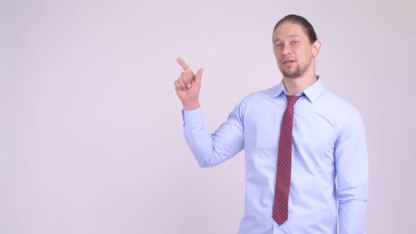 Happy Handsome Businessman Thinking and Pointing Up alt