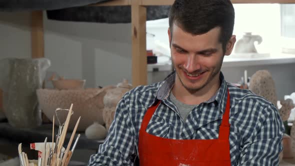Handsome Cheerful Male Potter Enjoying Working at His Studio alt