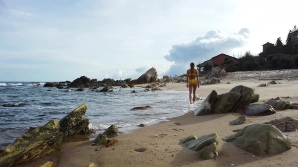 Sexy attractive blonde woman walking barefoot in bikini on tropical beach, long hair woman enjoying alt