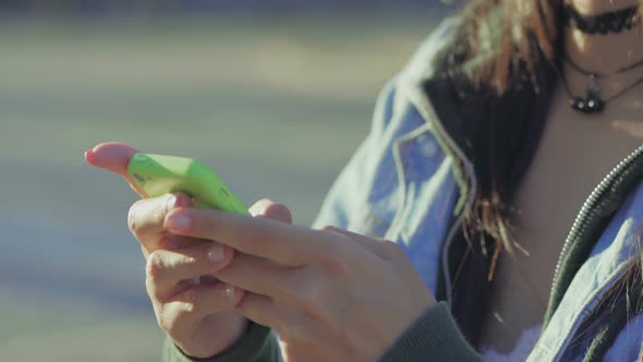 Closeup View of Female Hands Texting on Green Smartphone alt