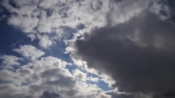 Time lapse: tense fluffy clouds cover the sun. Sun rays brake through clouds. alt