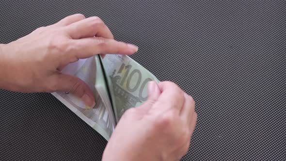 Hand holding euro paper currency and counting 100 euro banknotes