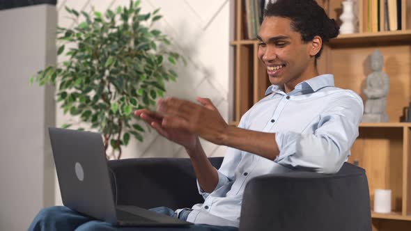 Cheerful AfricanAmerican Male Freelancer Using Laptop for Video Connection