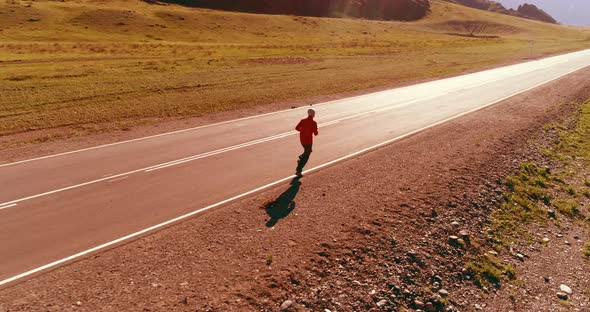 Low Altitude Flight in Front of Sporty Man at Perfect Asphalt Road alt
